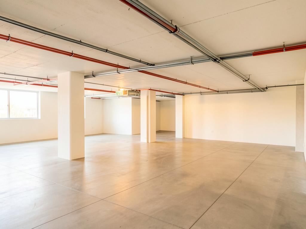 Helle Tiefgarage mit geordneten Kabeltrassen und Leitungswegen an der Decke